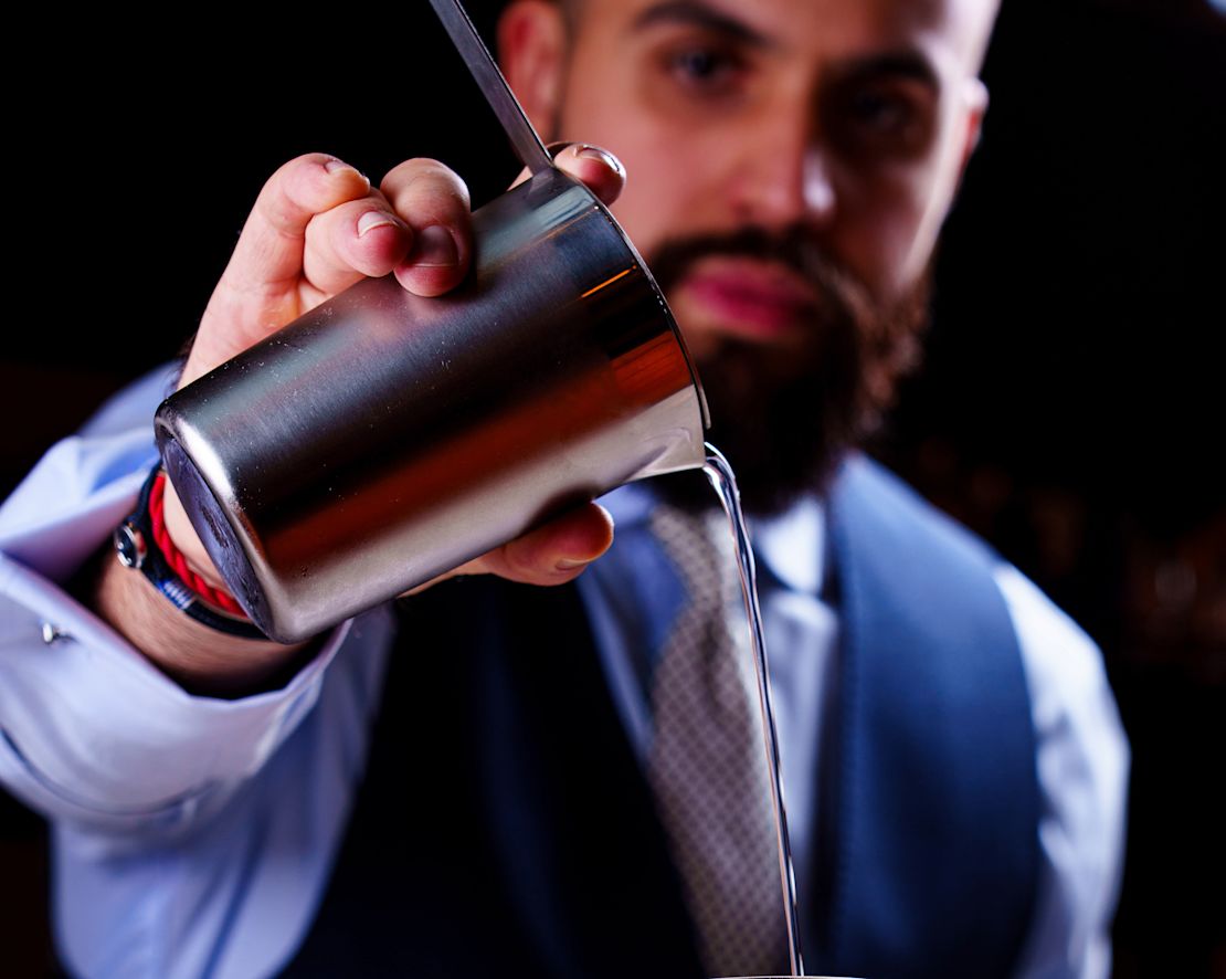 A Bartender pouring a cocktail-transition
