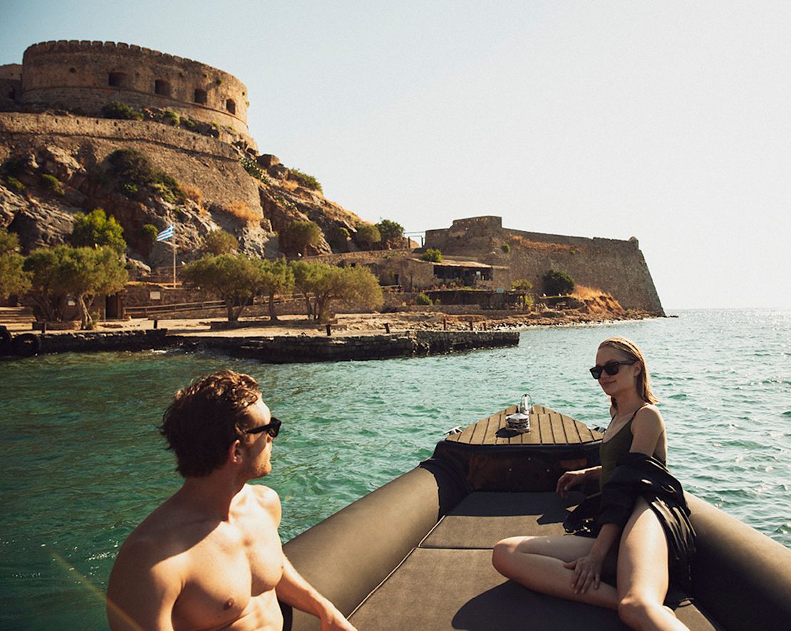 Pár odpočívá na lodi poblíž historické pevnosti.-přechod