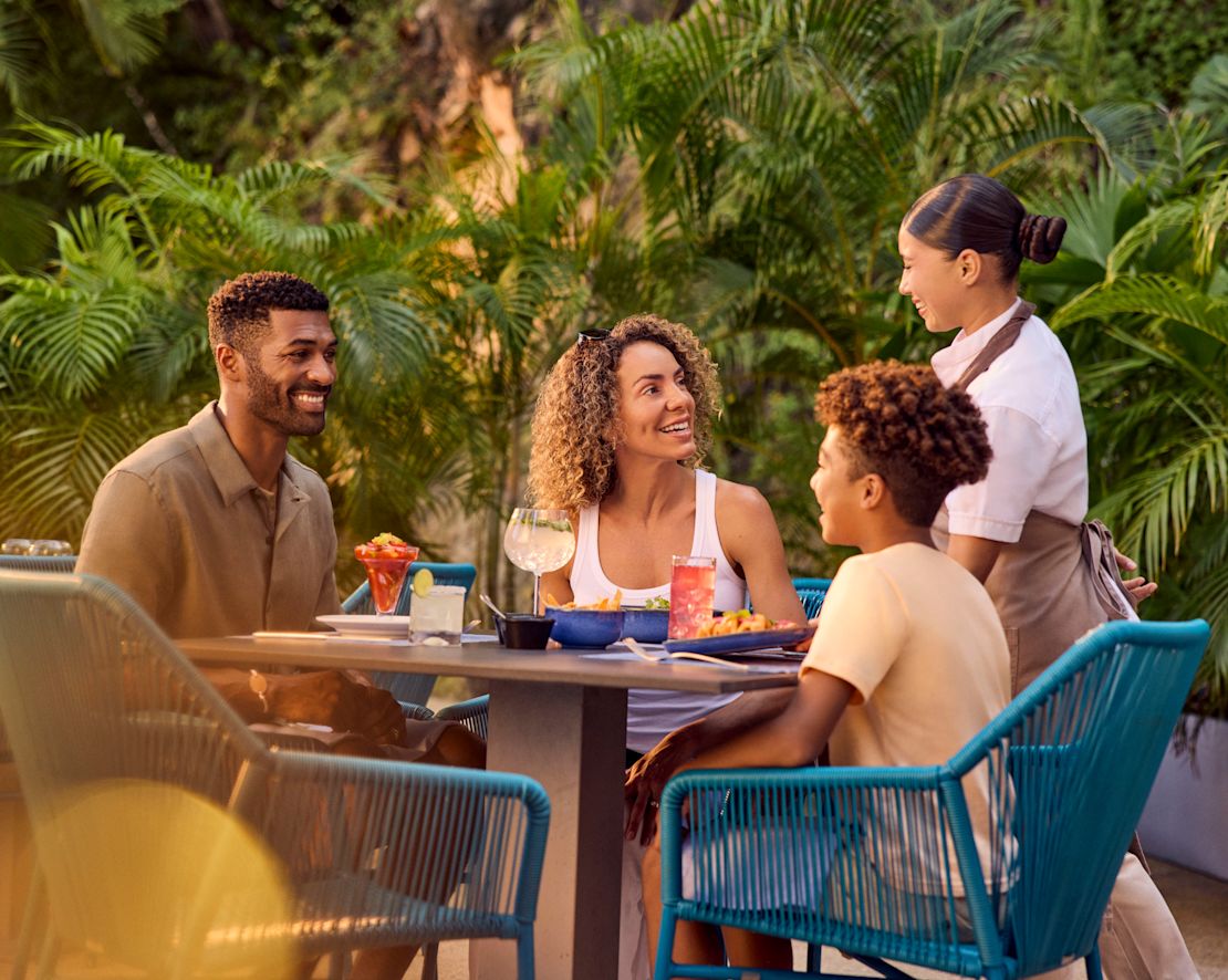 Restoran terasında yemek yiyen baba, anne ve oğul