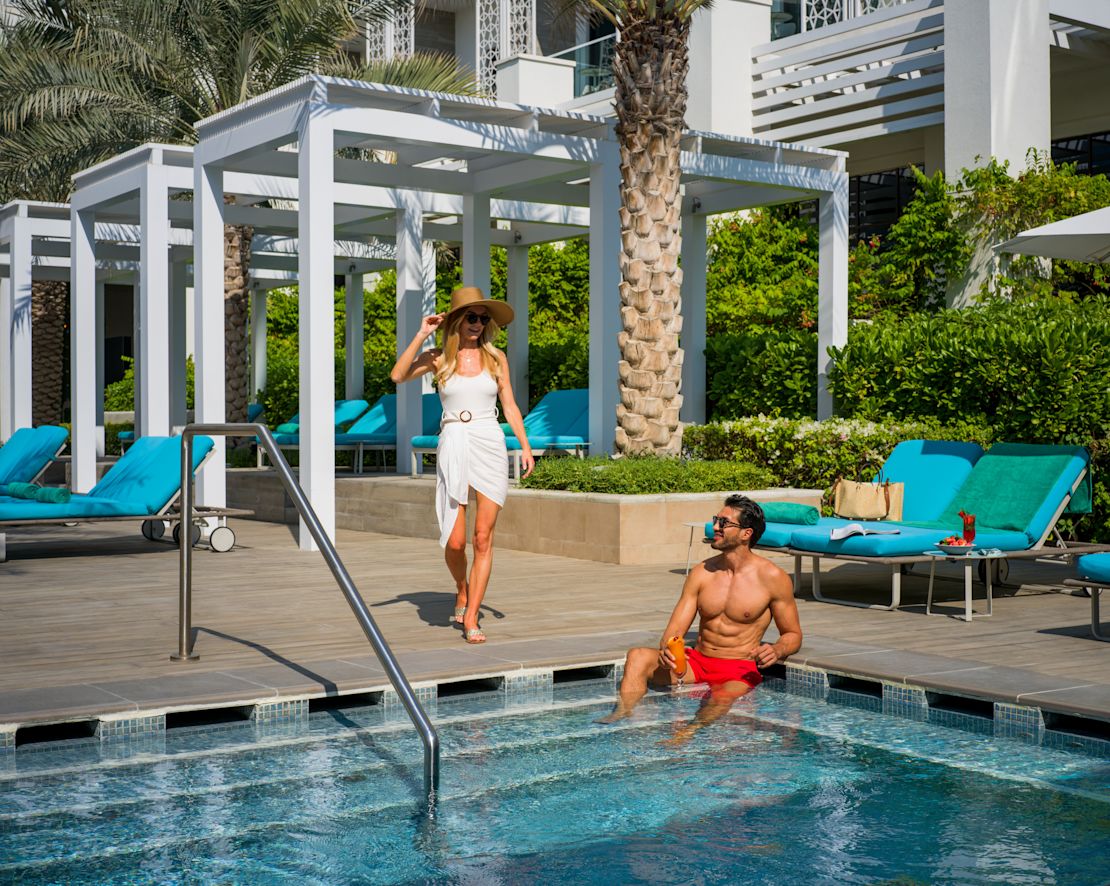 Couple in Outdoor Pool Area with Lounge Chairs-transition