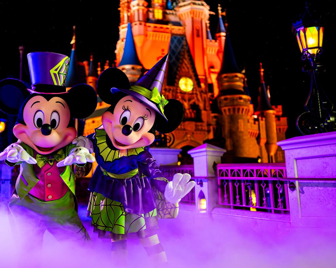 Mickey and Minnie mascots at park at night-transition