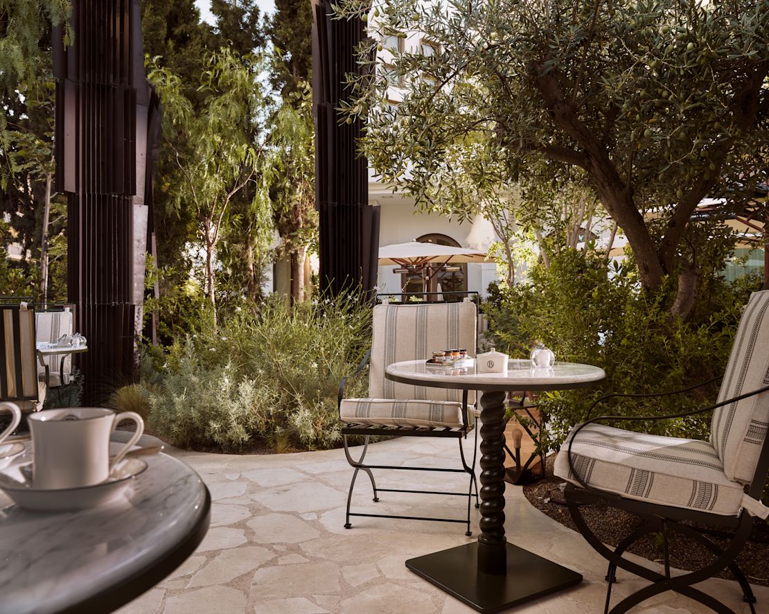 Tavolo da pranzo al patio della grande Brasserie Byzantino con piante e alberi