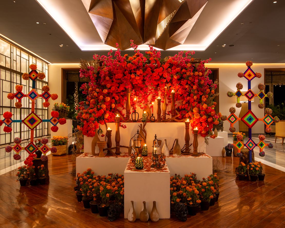 Ein mit Blumen und farbenfrohen Kunstwerken dekorierter Bereich zur Feier des el Dia de los Muertos-Übergangs