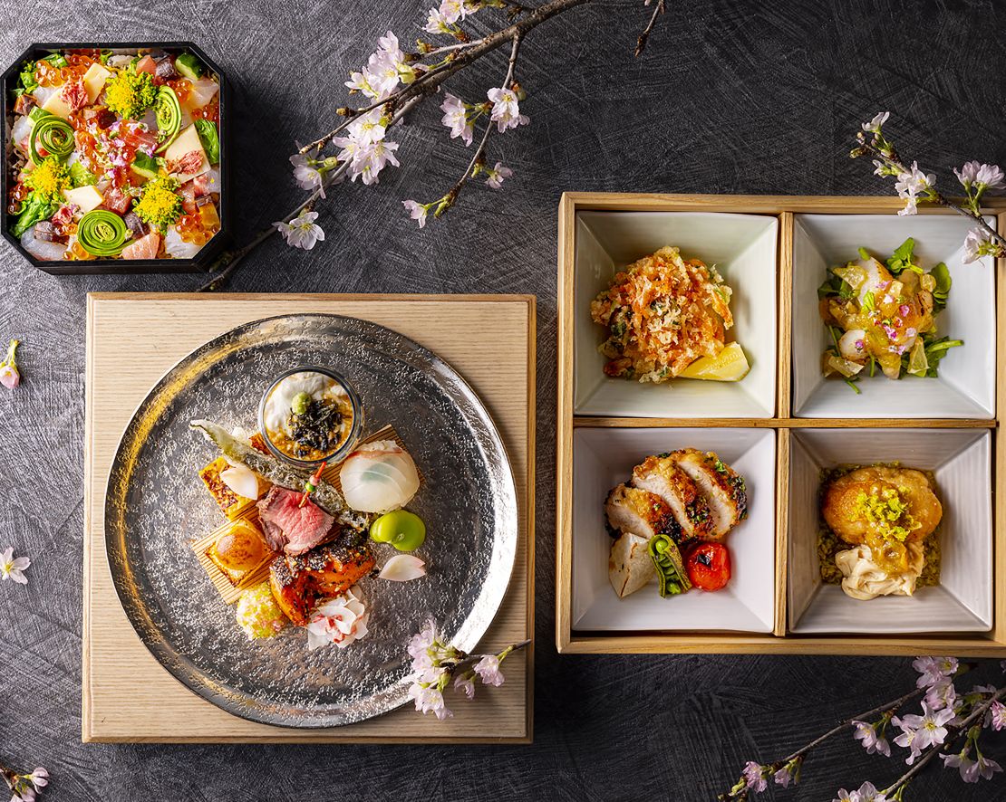 Blick über den Kopf auf die Teller auf einem Tisch mit Blumen, die über den Übergang verteilt sind