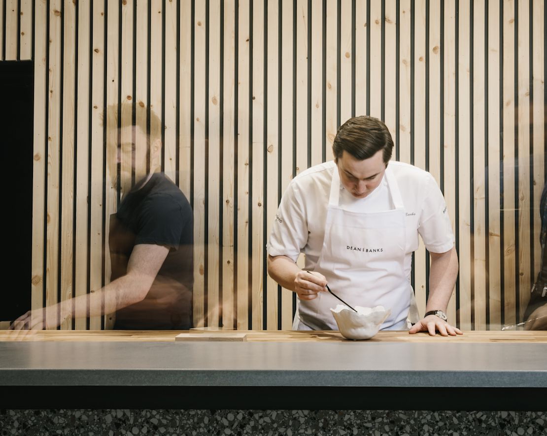 man in apron stirring in a bowl-transition