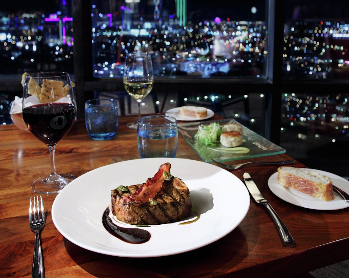 Steak on plate with Dallas at night in background-transition