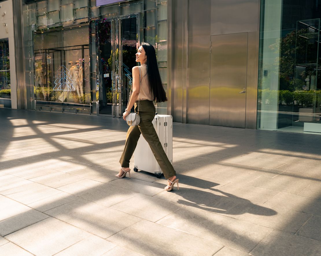 여행 가방을 가지고 걷는 여성