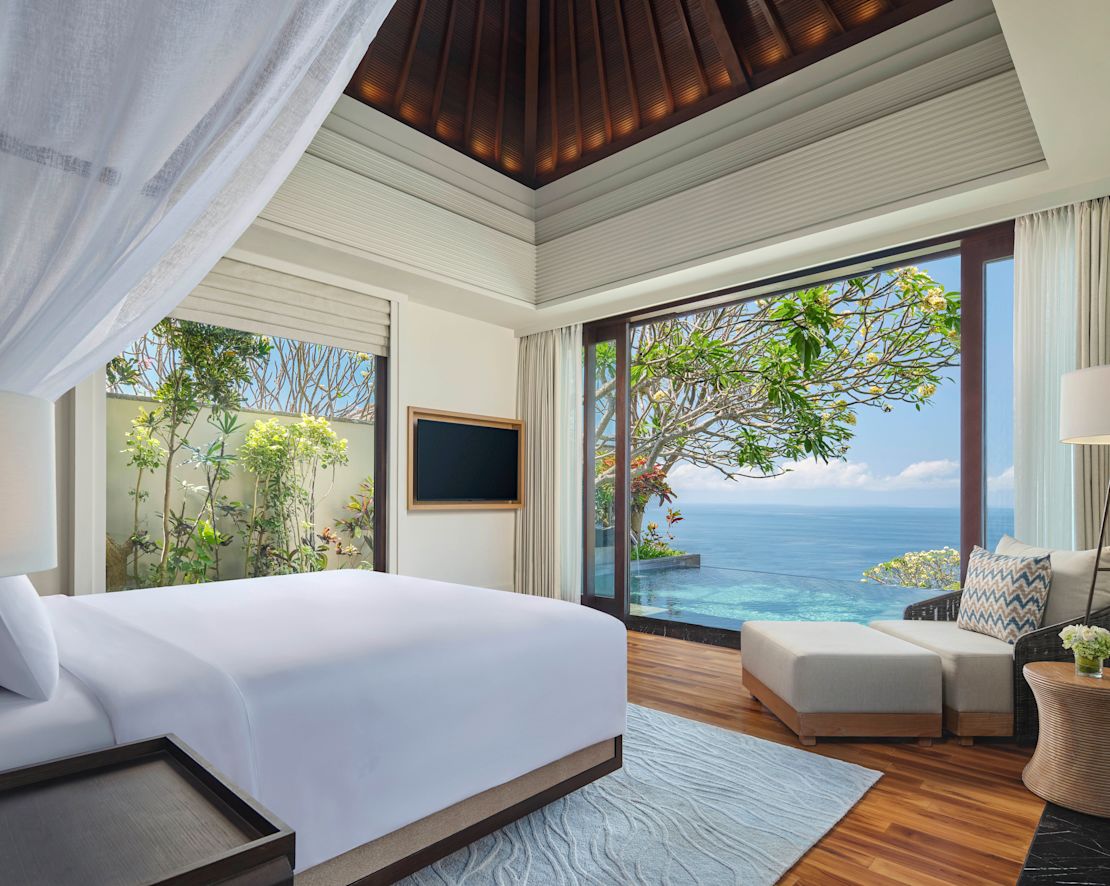 Großes Bett in einem Zimmer mit HD-Fernseher, Swimmingpool und Meerblick – Übergang