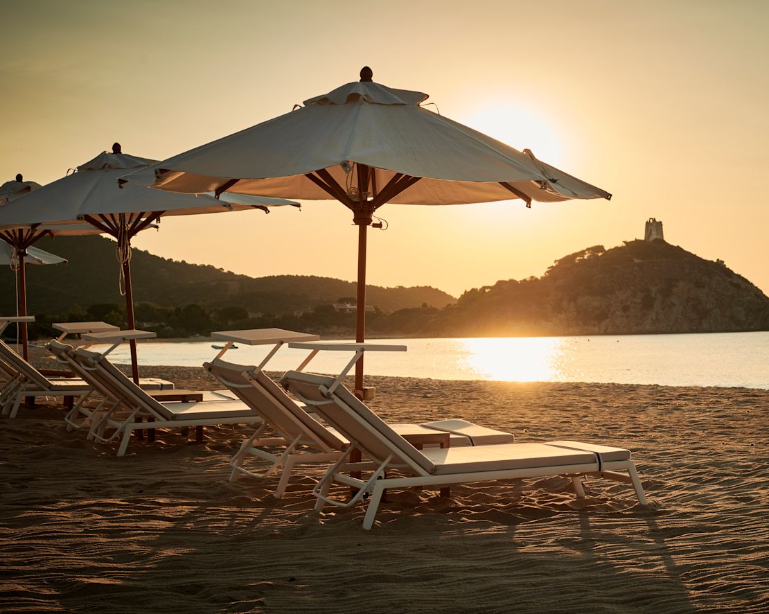 Lounge Chairs Under Umbrellas on The Beach At Sunset-transition
