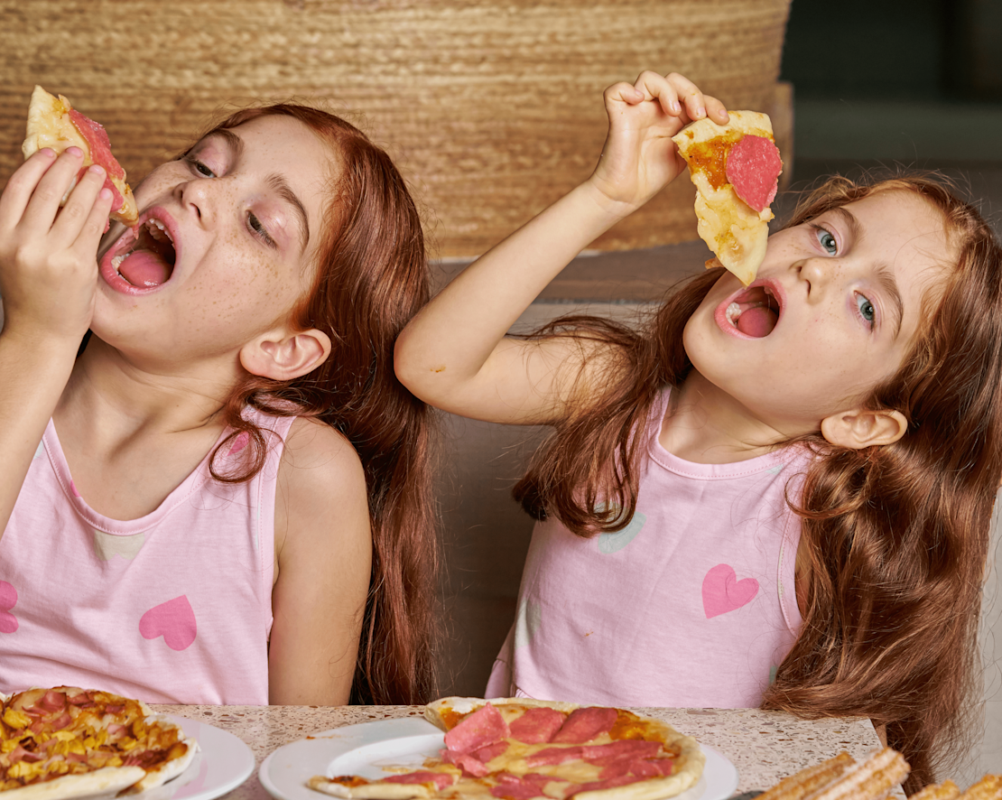 Doi copii bucurându-se de tranziția cu mâncare