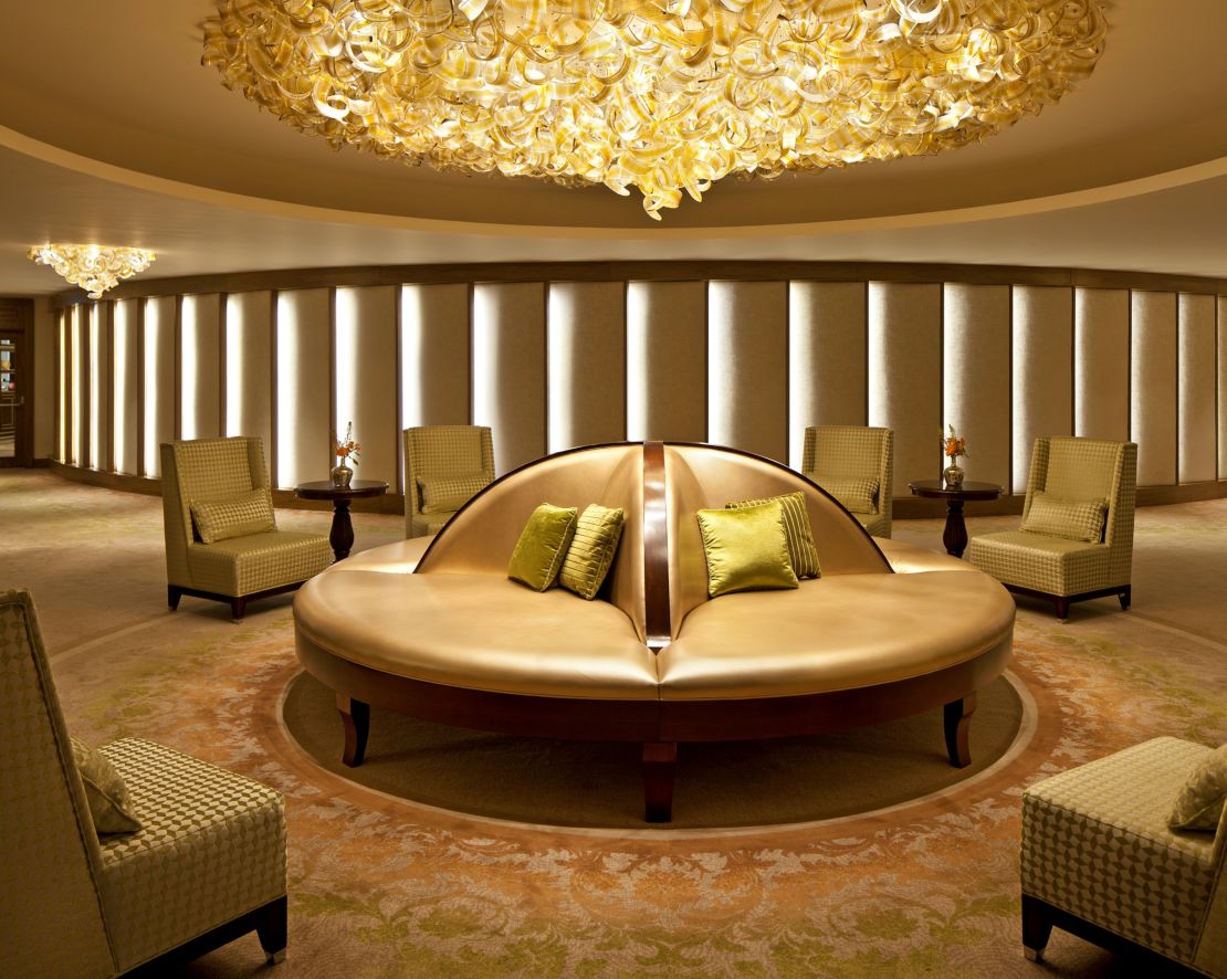 Lounge Area with Circular Settee, Satin Pillows, Chandeliers, and Recessed Lighting-transition