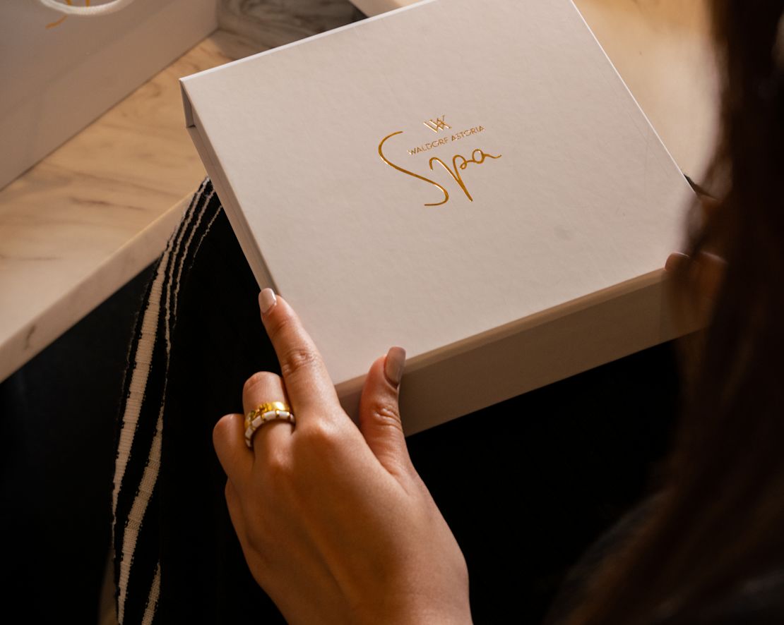 Boîte cadeau de spa pour une personne tenant des huiles derrière la transition