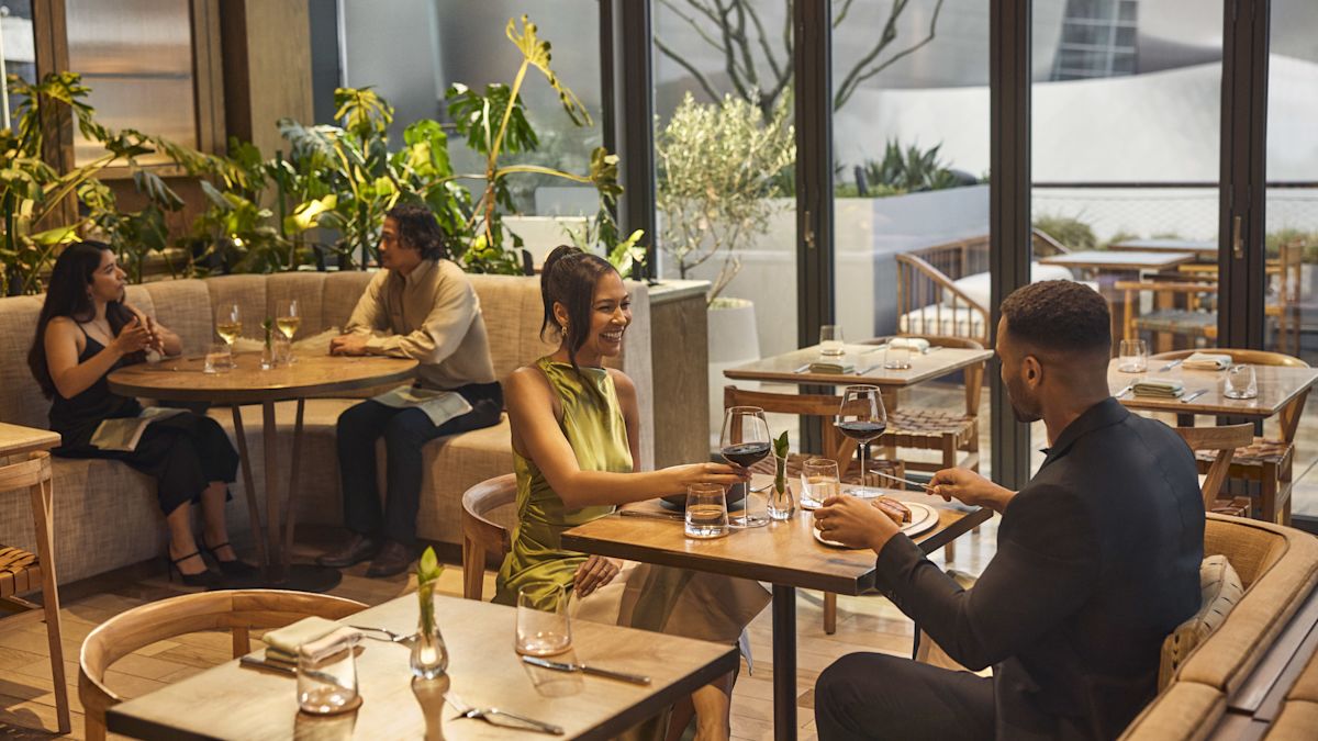 Homem e mulher na área de estar do restaurante com bebidas e comida