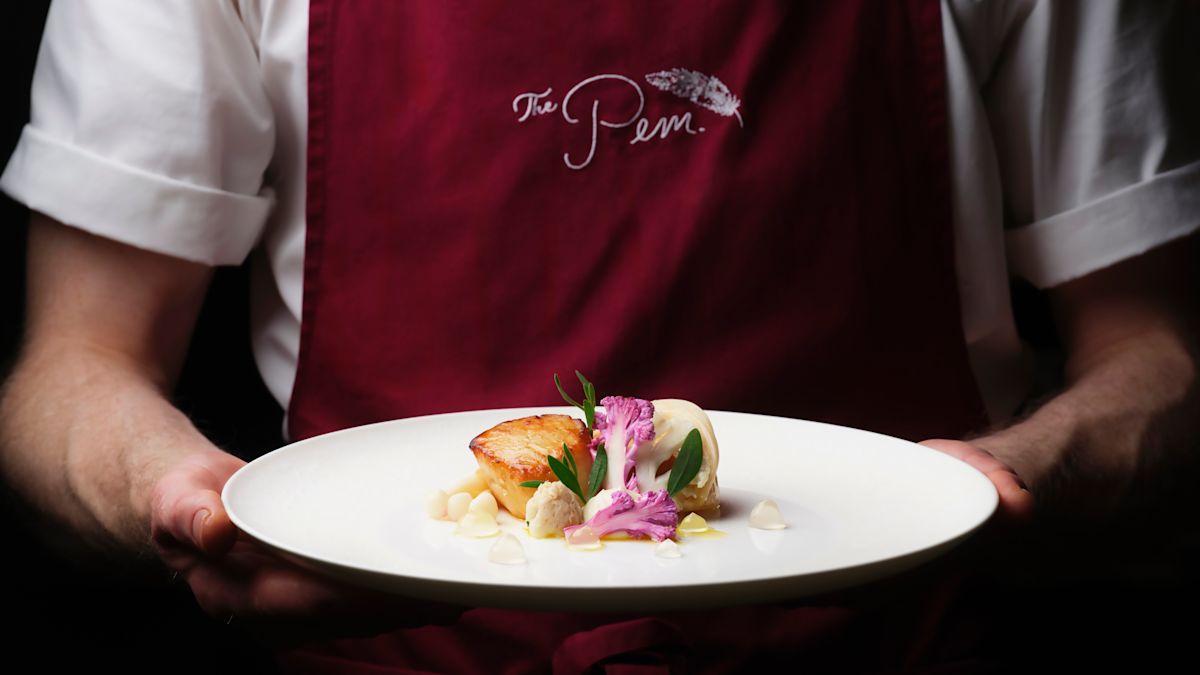 The Pem chef holding a dinner entree plate