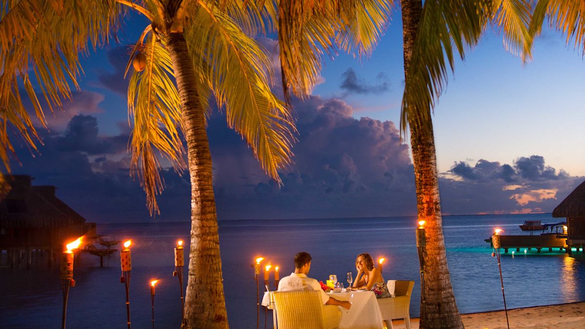 Stel dat bij zonsondergang een romantisch diner op het strand houdt