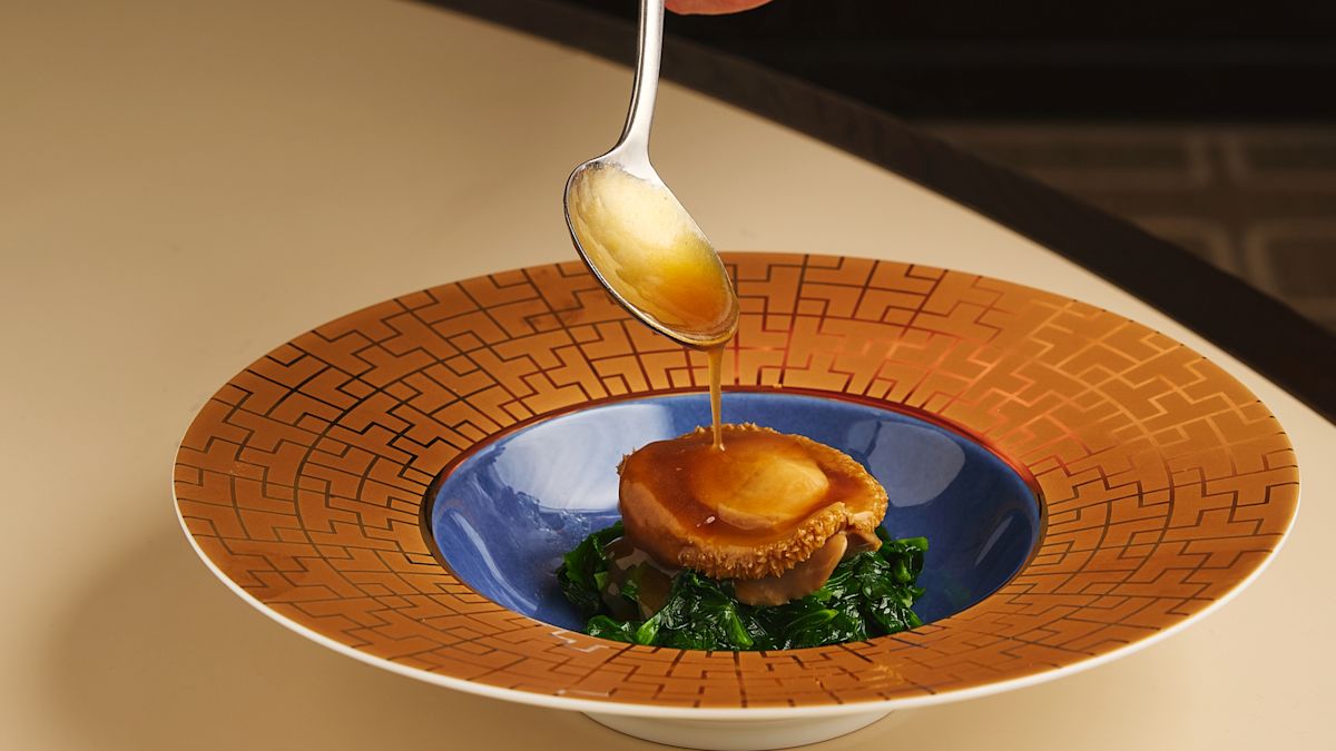 Image du palais d'été, avec le chef en cuillères de sauce sur l'assiette