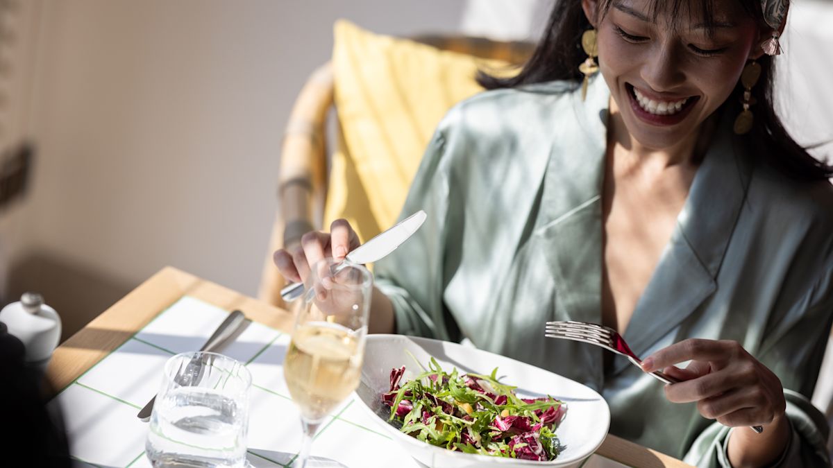 Person am Tisch mit Speisen