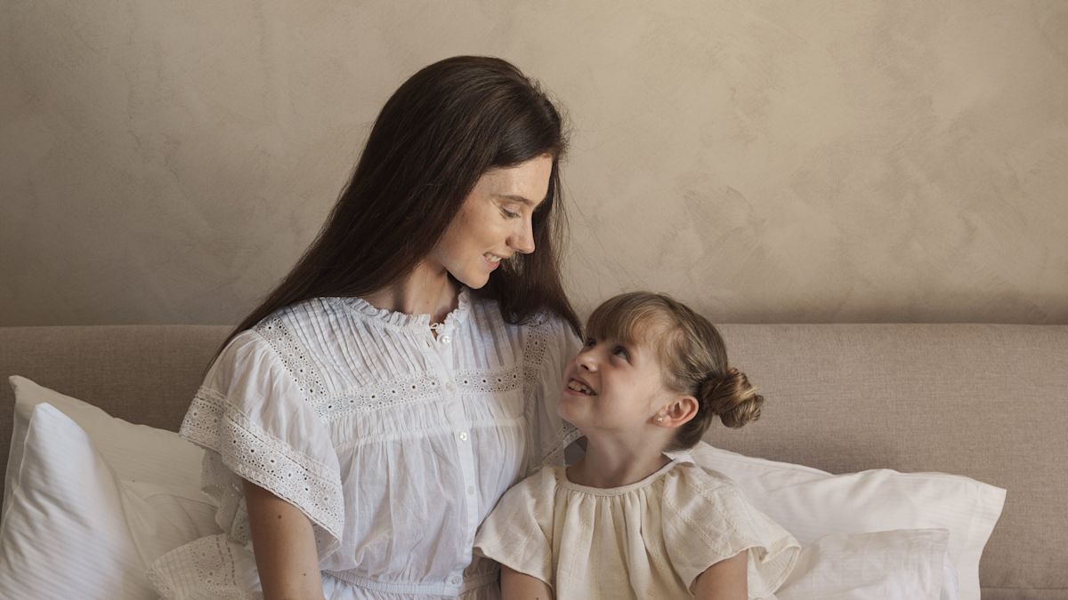 Mother and Daughter on a Bed in a Hotel Room