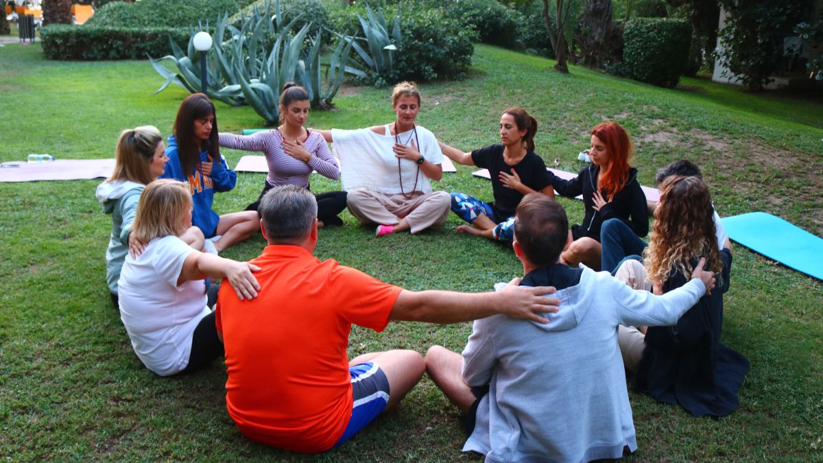 Group of people sitting in a circle on the grass