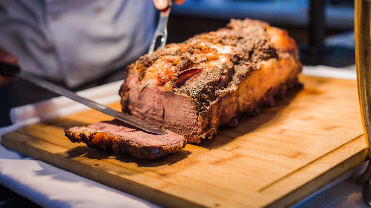 Person Cutting Meat at Garden Terrace Restaurant