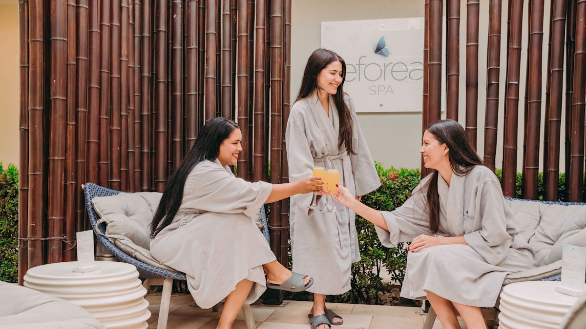 Three women in robes toasting glasses