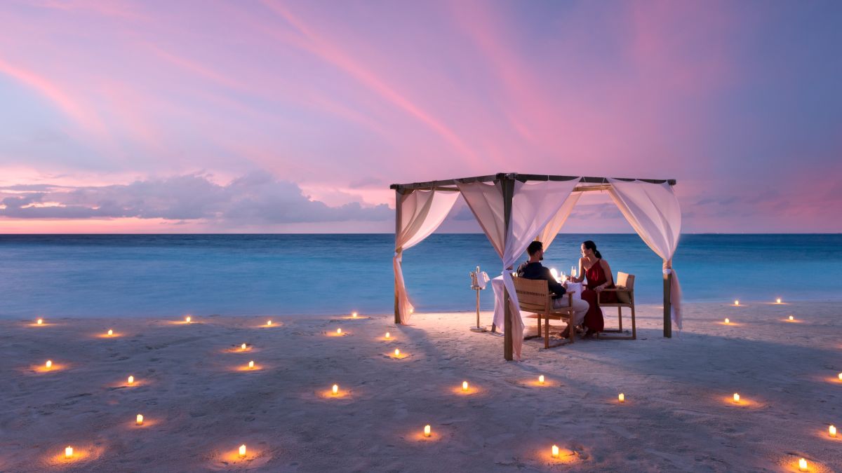 couple at outdoor dining table on the beach