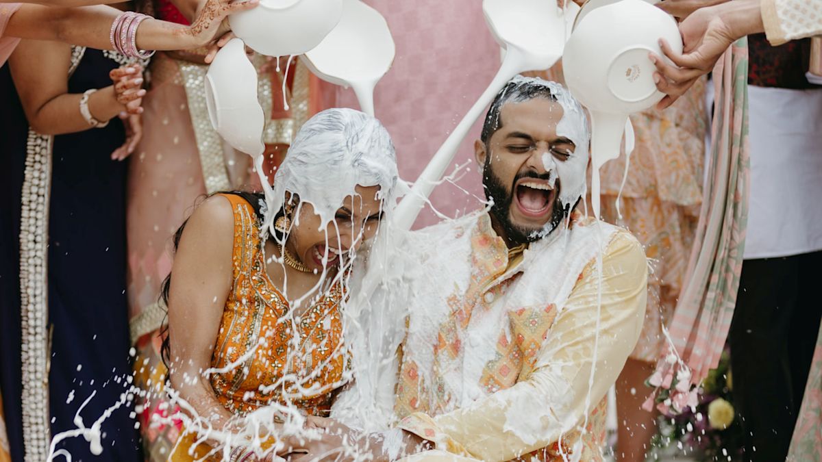 Wedding ceremony with bridge and groom being covered in white liquid