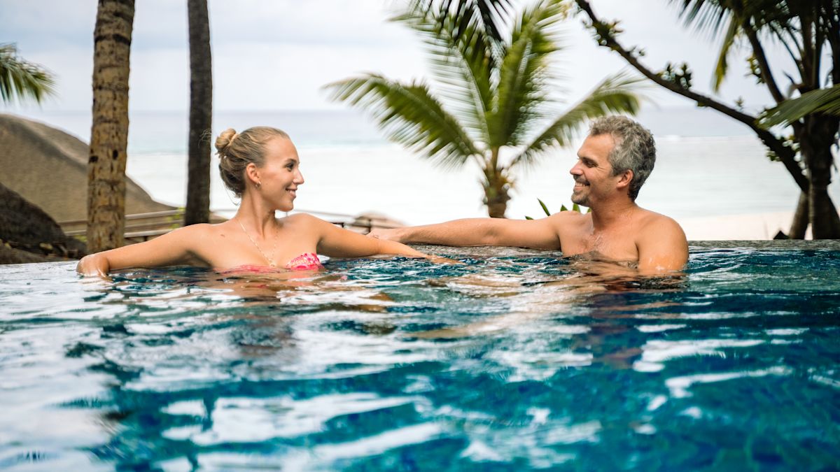 a couple enjoying a whirlpool outdoors next to a beach