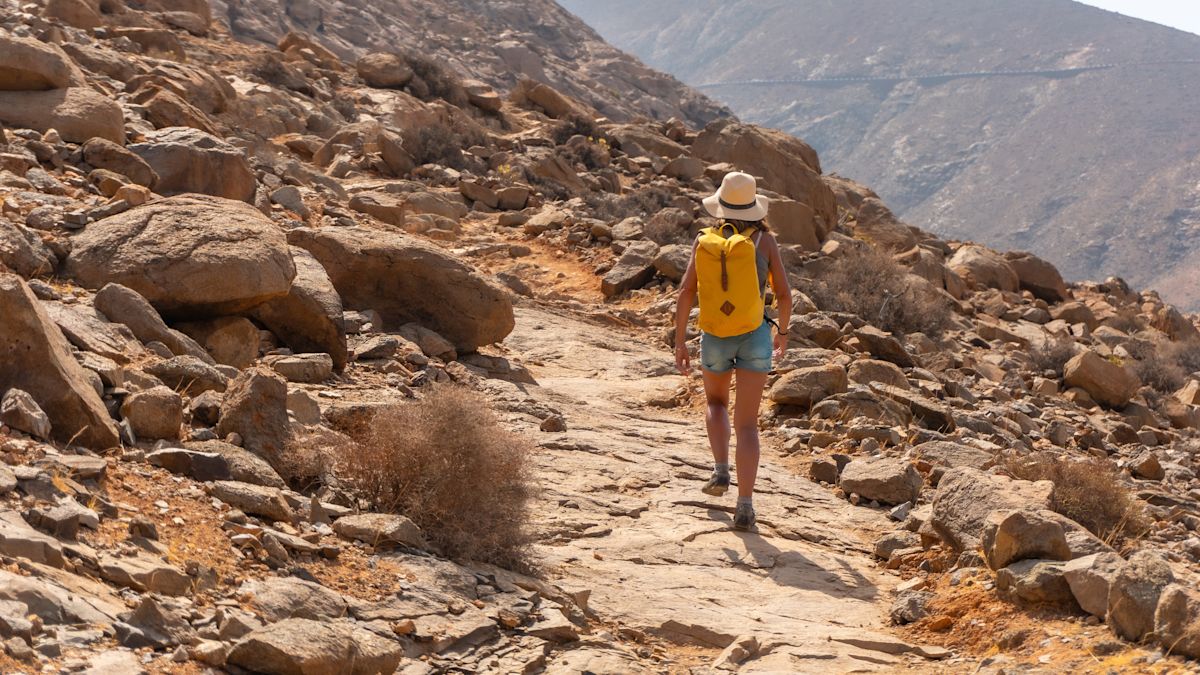 Femeie cu rucsac în deșert