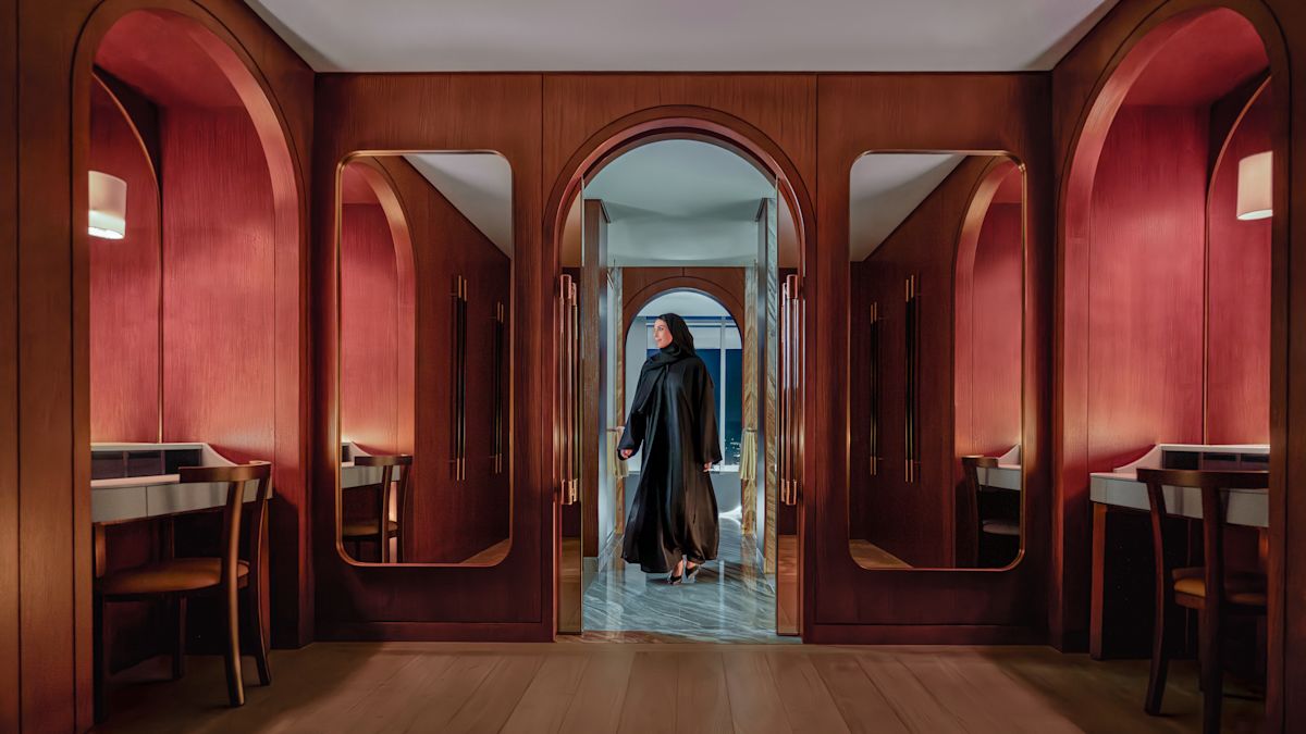 Woman stepping through guest room entrance into room
