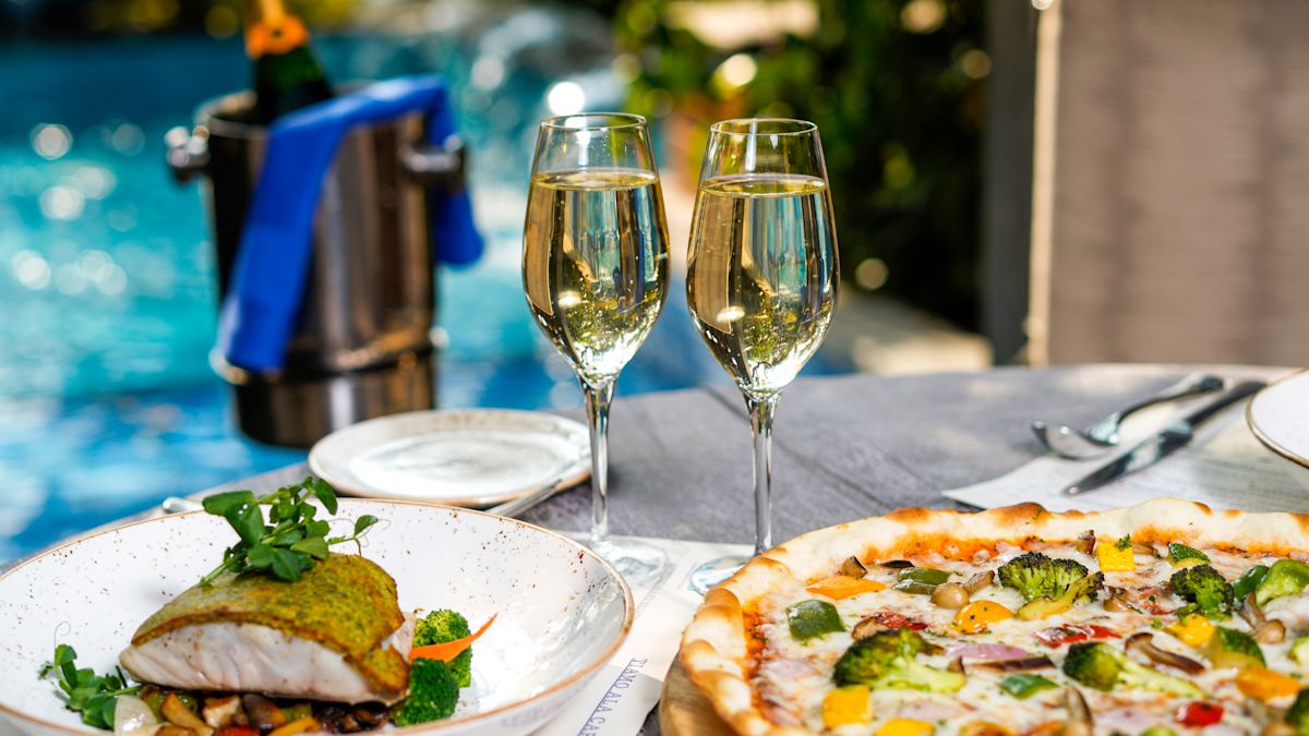 Champagne and two meals on plates outside