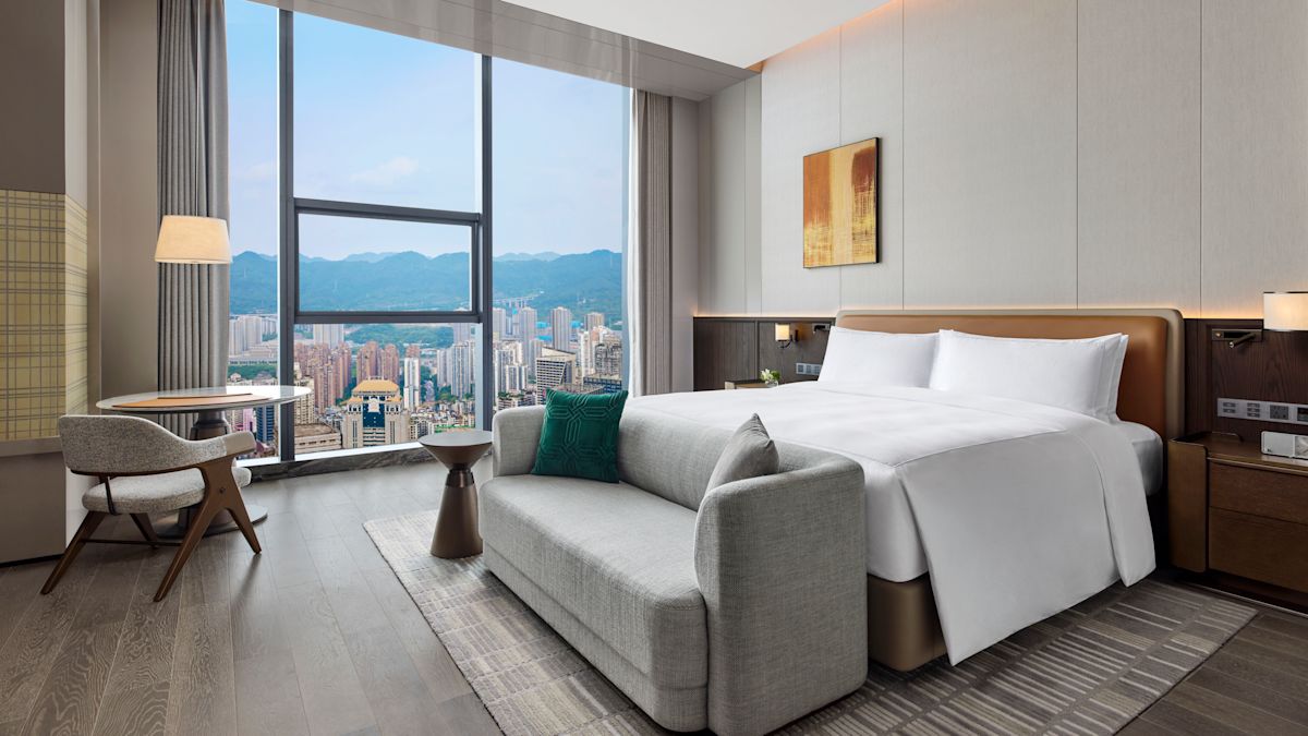City View from a Guest Room with a Large Bed and Sitting Area
