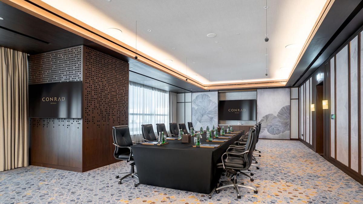 Sala de reuniones Reem con mesa grande para 12 personas y televisor
