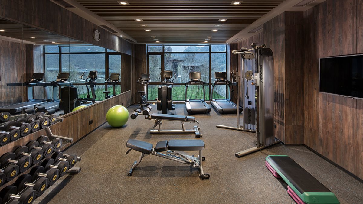 Centrum fitness, maszyny do ćwiczeń cardio i obciążników oraz ławka do bezpłatnego ważenia