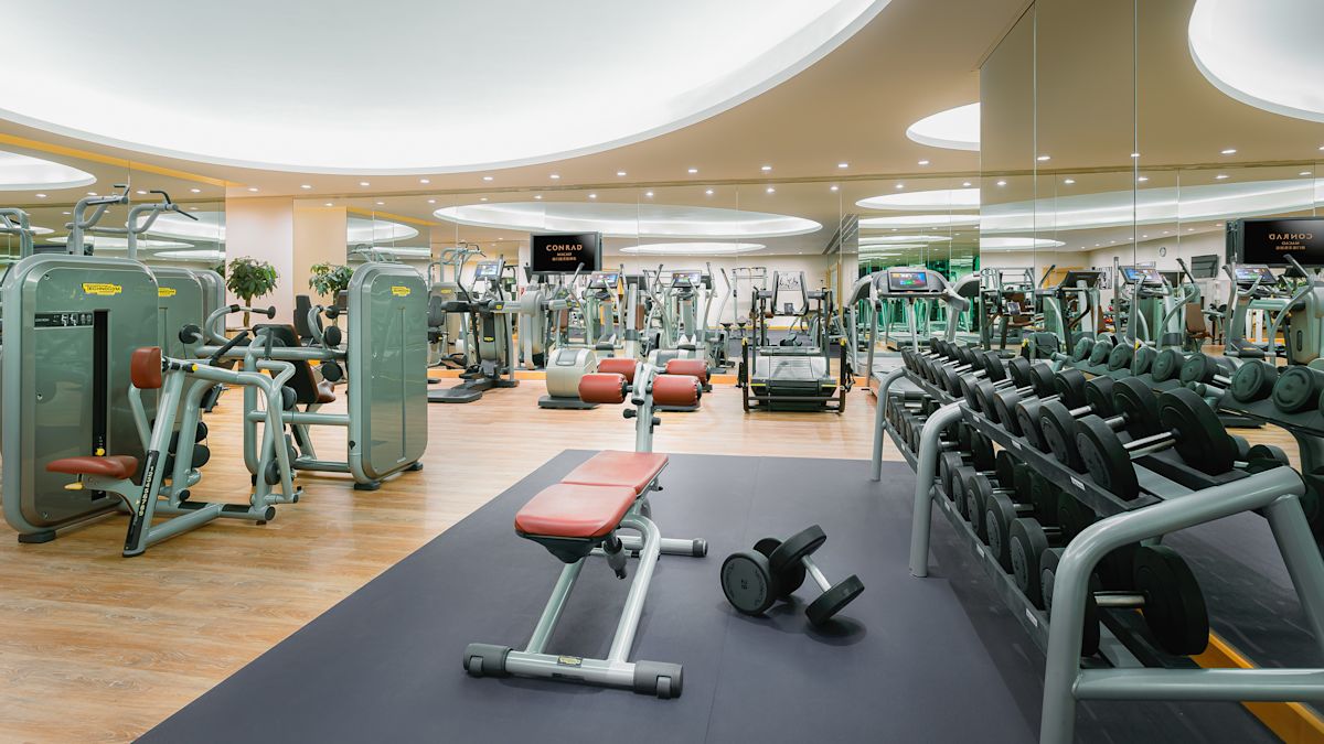 Stort fitnesscenter med vikter, löpband och annan modern träningsutrustning