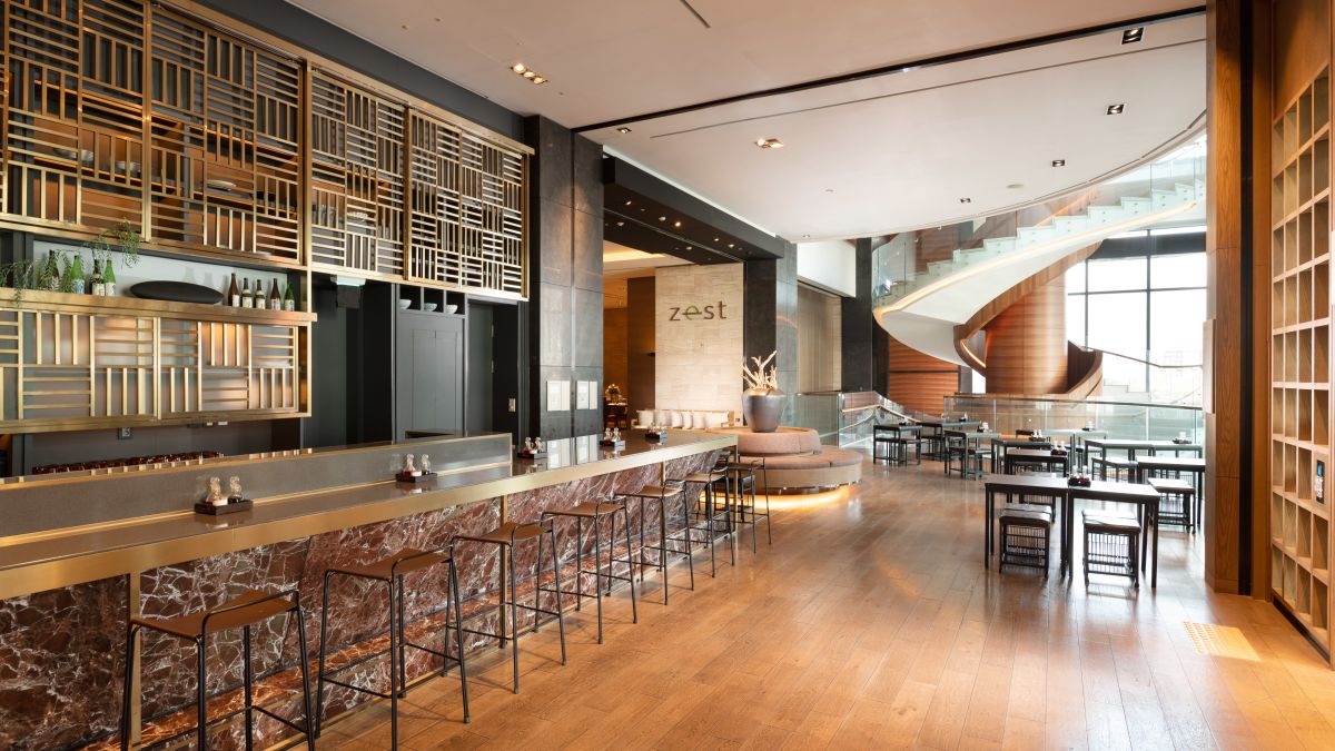 Interior of the Noodle Bar. The bar is complete with gold detailing, and you can see the modern spiral staircase featured in the lobby below.