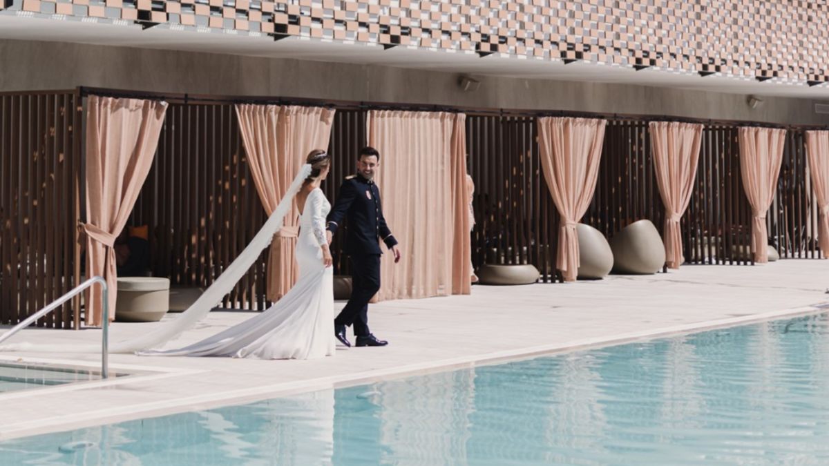 Wedding couple walking alongside pool