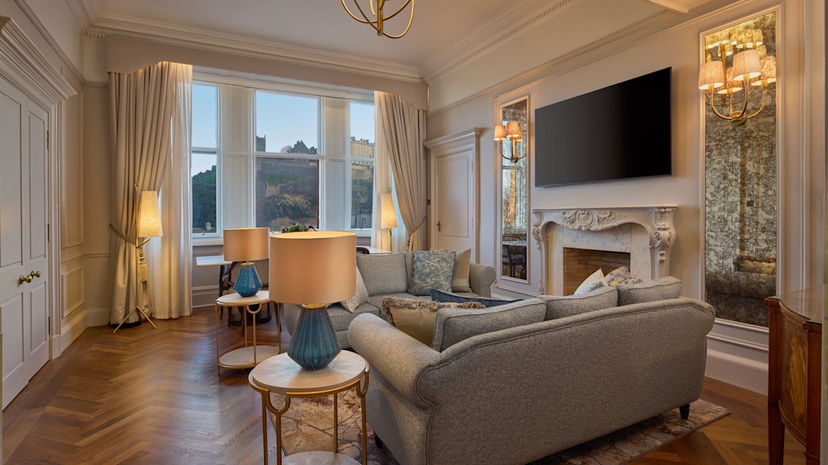 Wohnzimmer der Suite mit großen Fenstern und Kamin