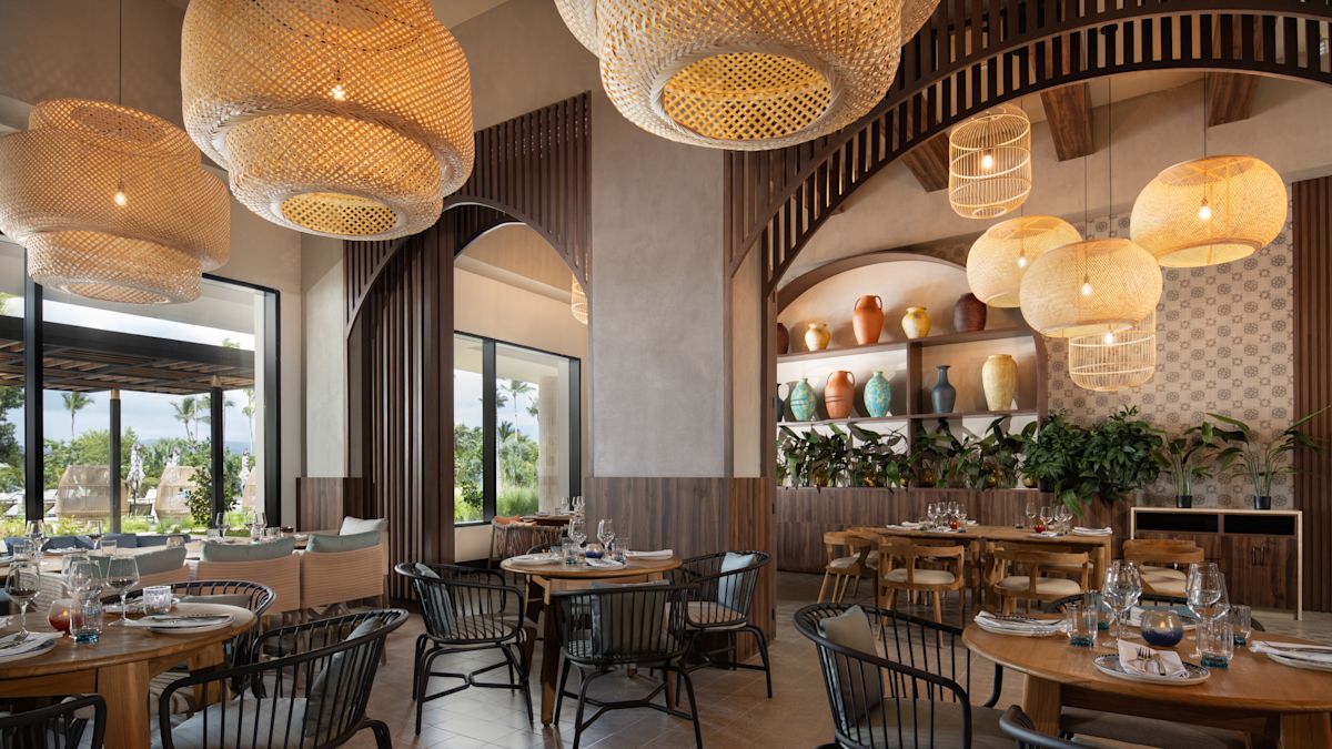 Disposición de los asientos de Manicato con grandes lámparas de mimbre entrelazado colgando del techo