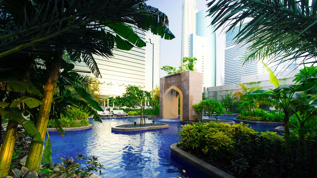 Outdoor Pool Area with Cascade and Gardens with Palm Trees