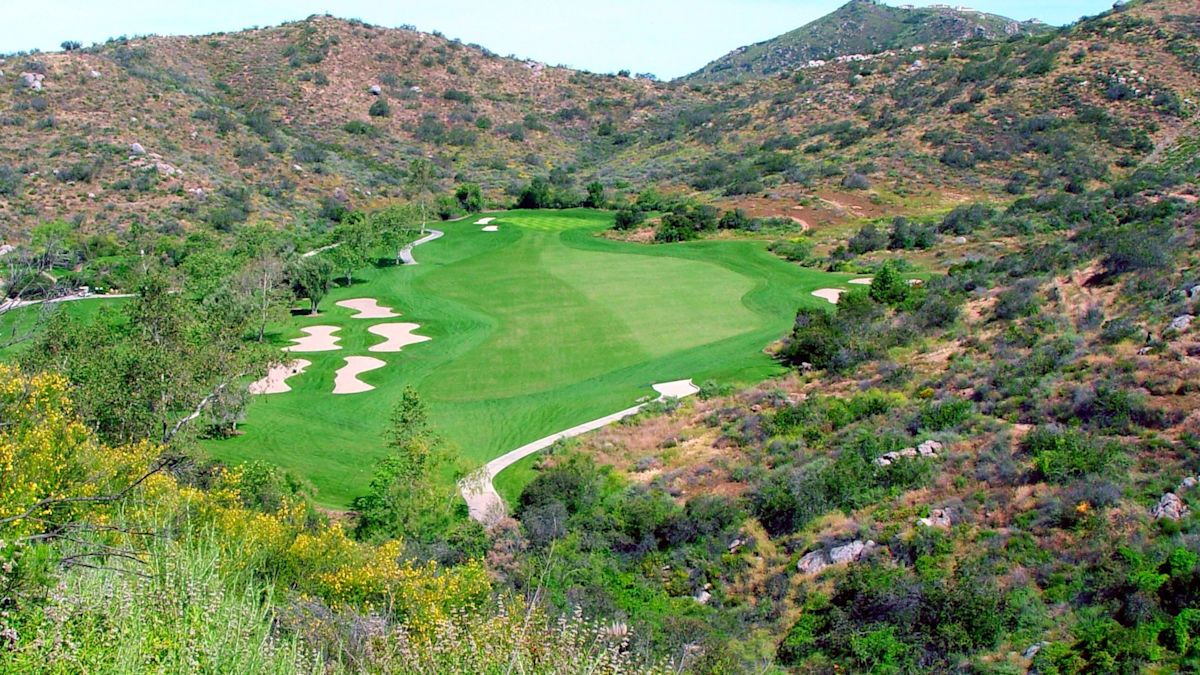Vedere aeriană a unui teren de golf înconjurat de munți