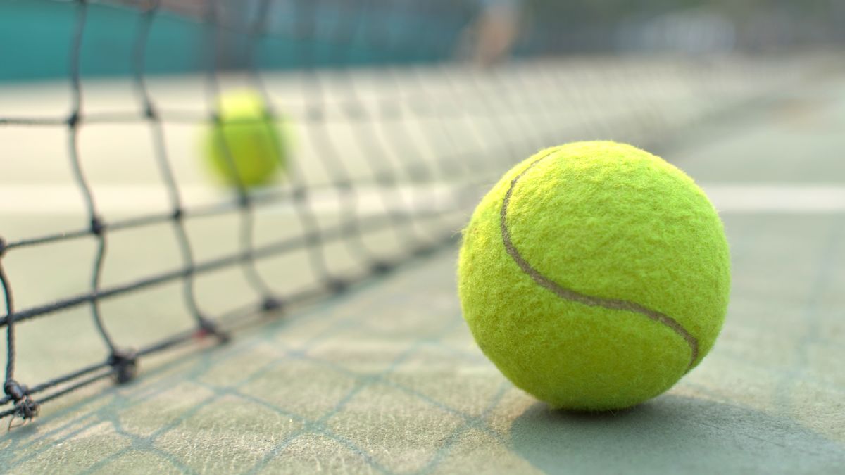 Closeup of tennis ball by net