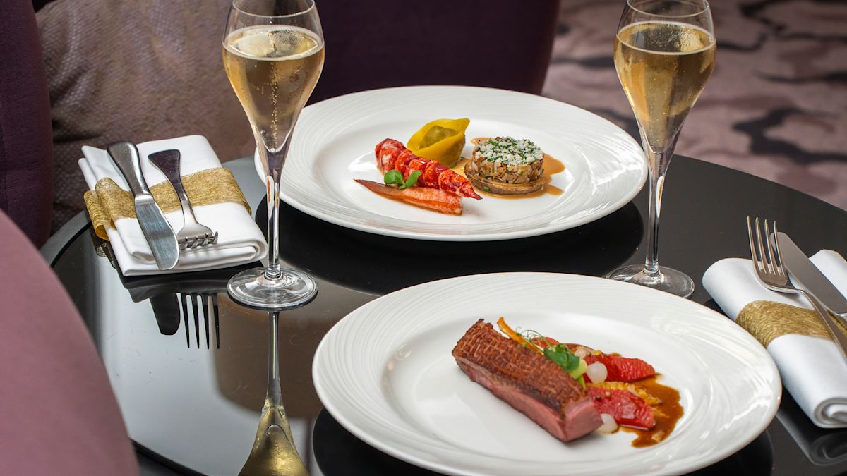 Zimmerservice mit zwei Gläsern Wein und Besteck auf dem Tisch