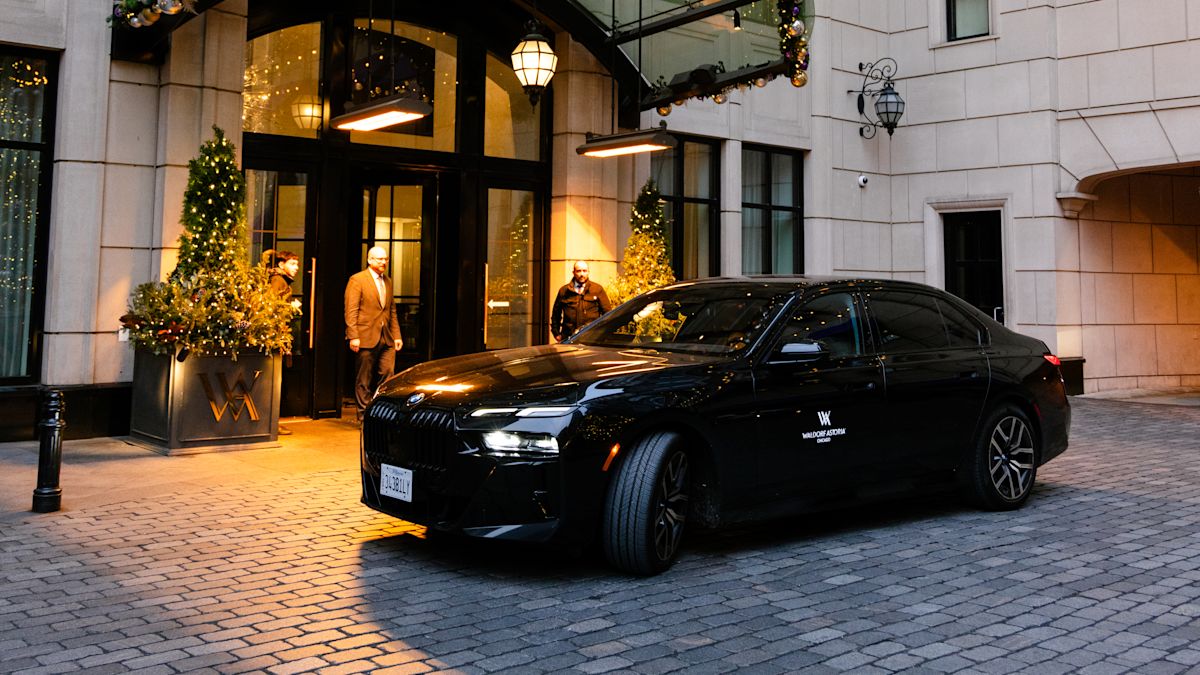 car parked in front of hotel's main entrance