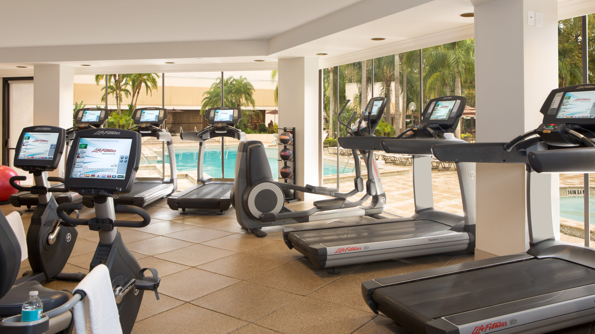 FItness Center with Modern Equipment and View of Outdoor Pool Area from Window