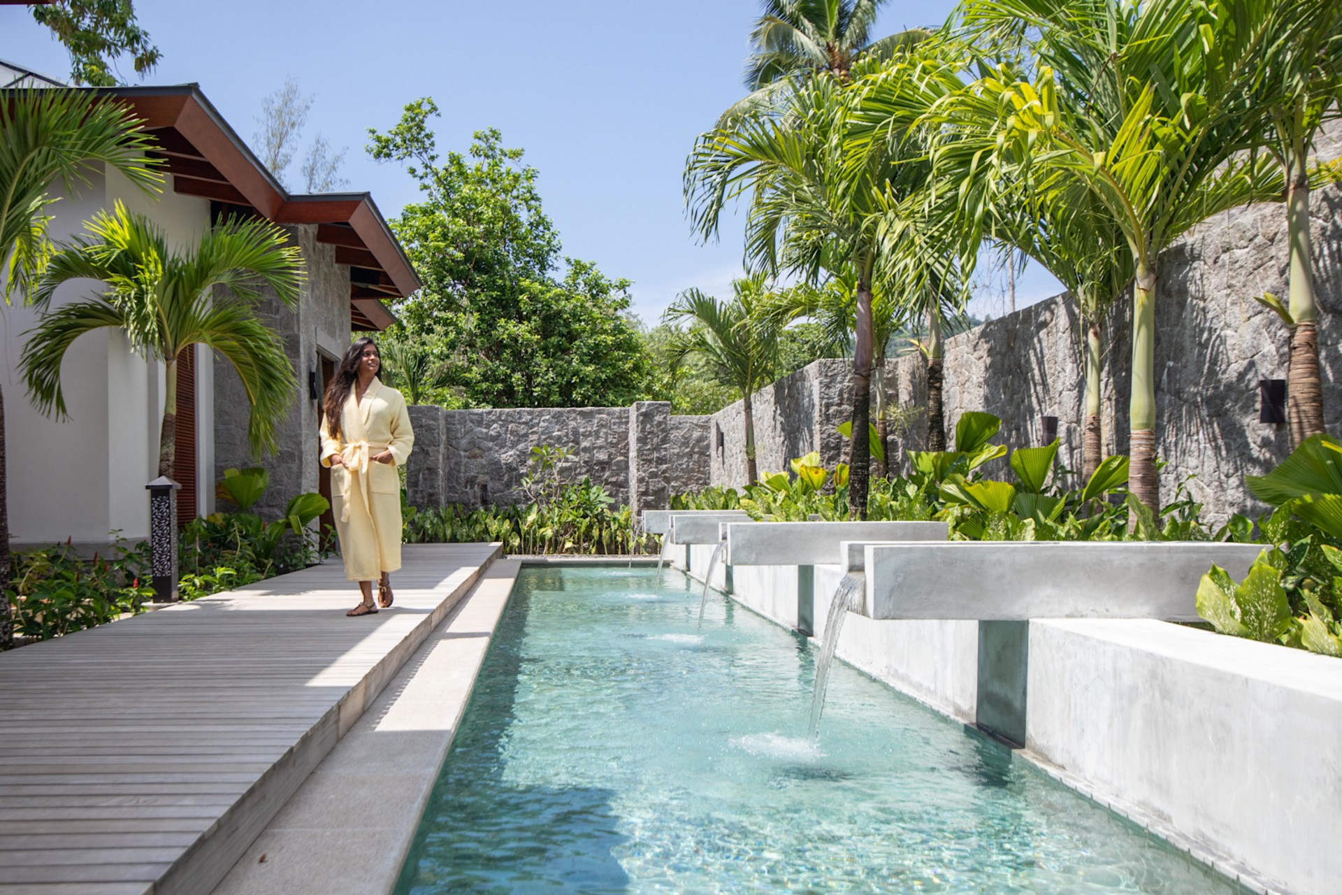 Woman Walking Outdoors at Afloya Spa with a Water Feature