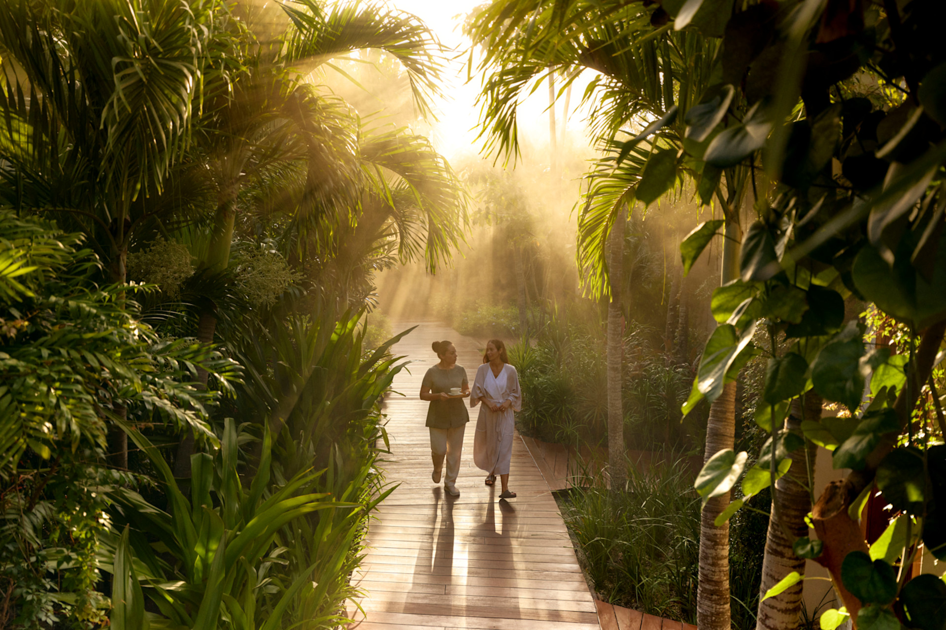 two women walking through garden area 