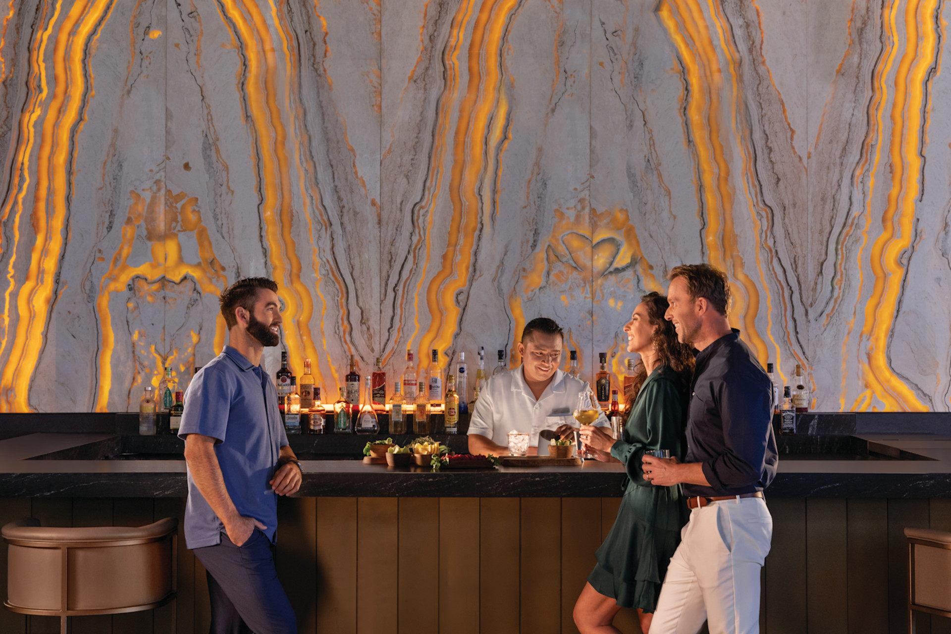 People stand around bar with drinks