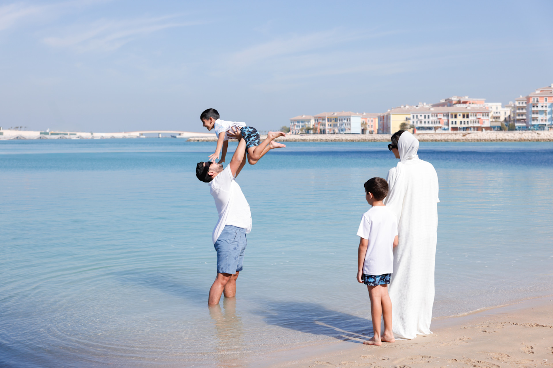 family standing in the ocean