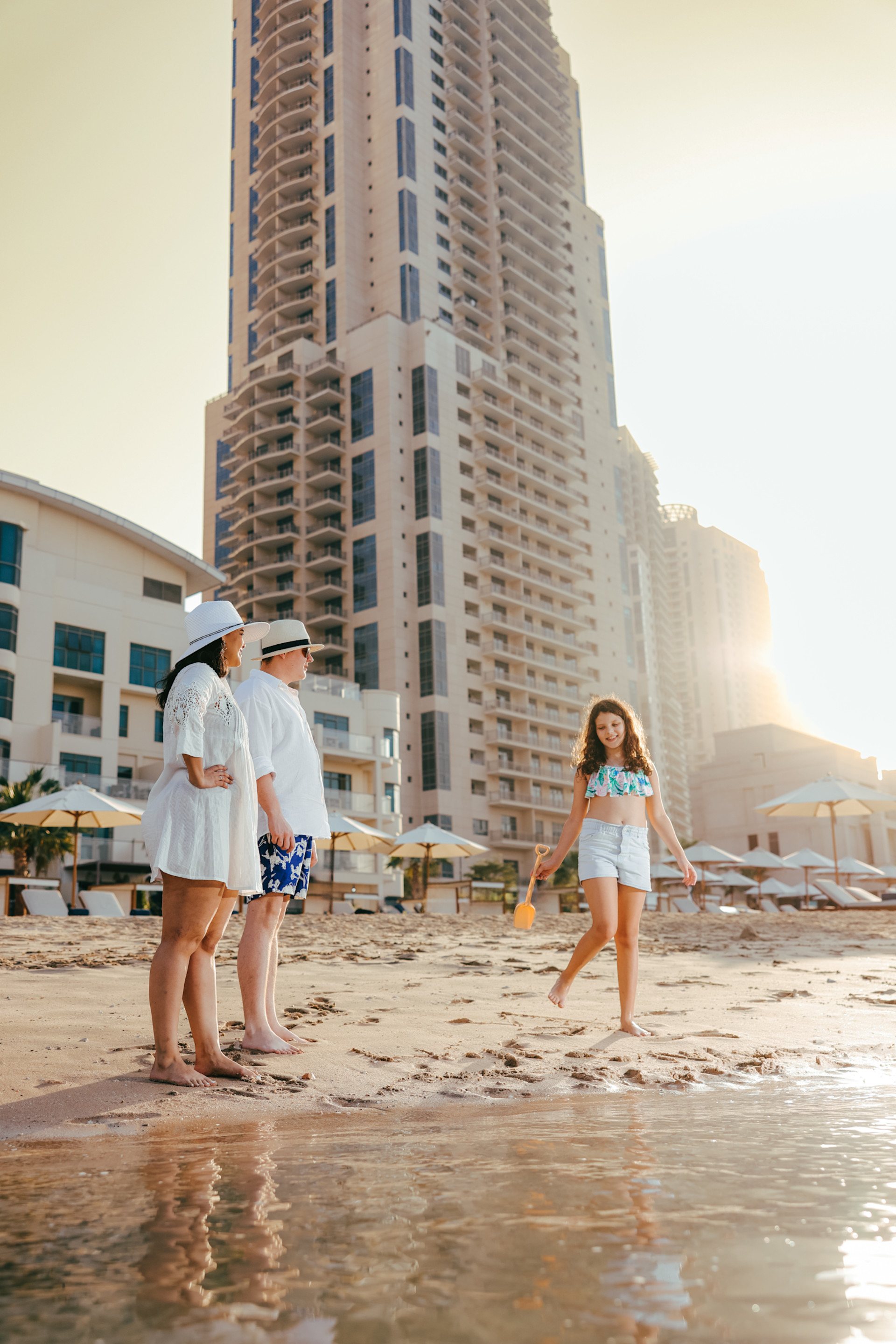people on beach in front of hotel